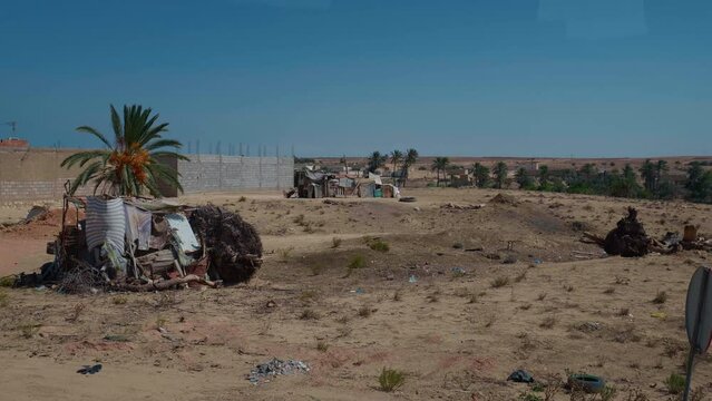 Side road view of unfinished constructions and outdoor settlements. Deprived part of the city living from odds and ends.