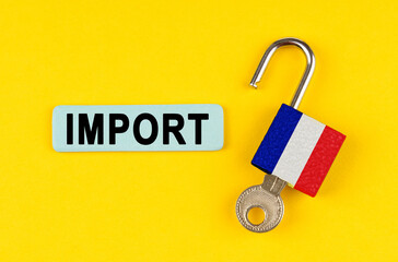 On the yellow surface is an open lock with a key and a sticker with the inscription - import