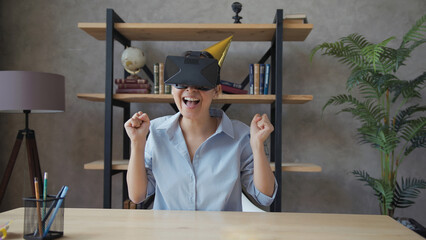 Asian woman wearing virtual reality glasses and rejoices celebrating birthday