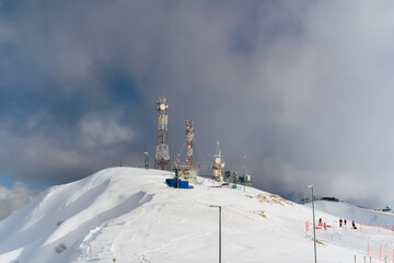 Antennas of communication equipment on top of a snowy mountain. Telecommunications tower high in the mountains. Rosa Khutor.