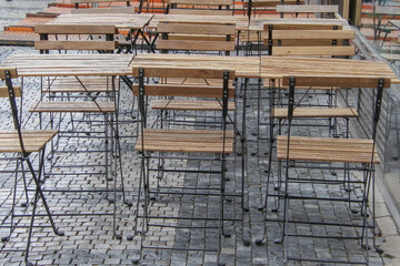 tables and chairs wet after rain in a street cafe on a stone paving