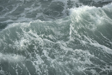 Fototapeta na wymiar Rough waves of sea with white foam