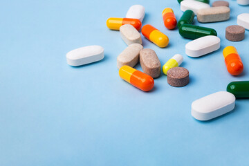 Top view of different pills on blue background,large banner with negative space.
