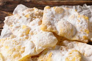 Traditional Italian Carnival dessert homemade Sfrappole or Chiacchiere on wooden background.