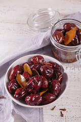 Preserving pickled plums in its own juice and seasonings on a wooden table. Healthy fermented food. Home canned vegetables.