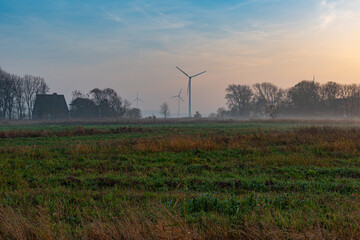 Ground fog in the dusk of the typical flat landscapes of East Frisia in the tourist resort of Norddeich directly at the north sea behind the dike
