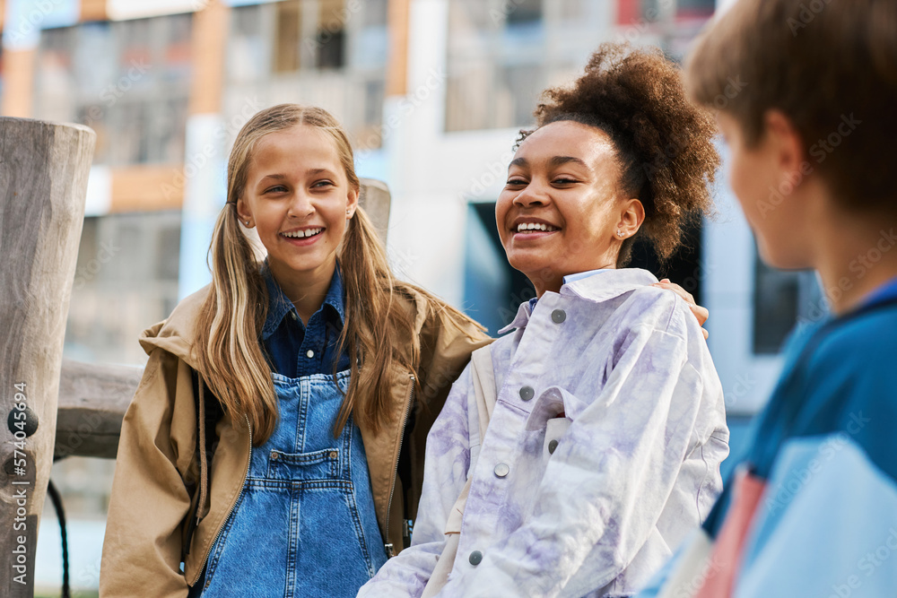 Wall mural cheerful cute secondary school learners of caucasian and african american ethnicities in casualwear 