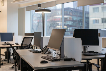 Open space in the office, computer desks and desktop computers, display screens for mock-up