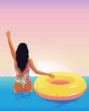 Rear view of woman at the beach swimming with rubber ring