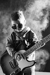Mały chłopiec gra na gitarze elektrycznej w okularach słonecznych - młody rockman - muzyka - gra - struny - obrazy, fototapety, plakaty