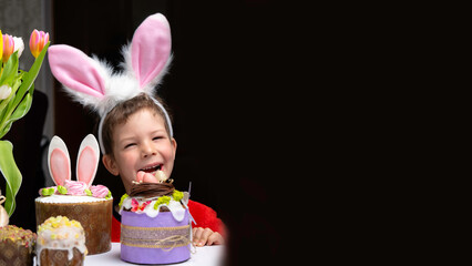 Cute little boy with bunny ears looking at tasty easter sweet cake