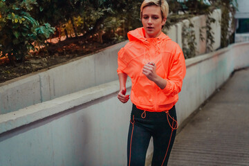 Women in sports clothes running in a modern urban environment et night time. The concept of a...