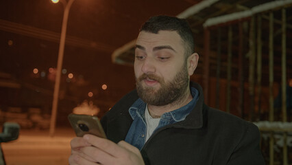 Shocked Face Bearded Tall Young Man Messaging on Phone in the Snowy Scenery