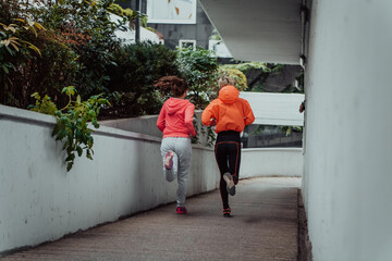 Two women in sports clothes running in a modern urban environment. The concept of a sporty and healthy lifestyle