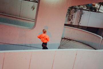 Women in sports clothes running in a modern urban environment et night time. The concept of a...