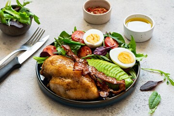 Plate with baked chicken fillet with bacon, fresh vegetables, salad. Popular keto diet, concept of healthy body, food.