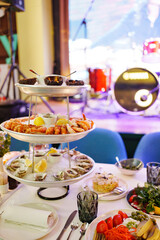 sea urchins, shrimp and shells with oysters on a platter with ice.