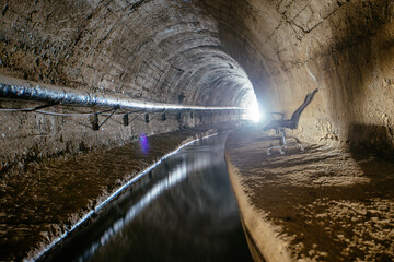 Underground vaulted urban sewer tunnel with dirty sewage