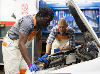 Fototapeta na wymiar Professional man car mechanician repairing car in auto repair shop
