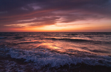 Sunset over the sea shore, sandy beach, colorful sky