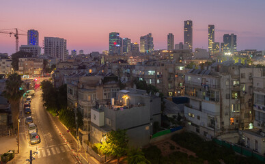 Fototapeta na wymiar Tel Aviv contrasts: old poor quarters and modern skyscrapers at night