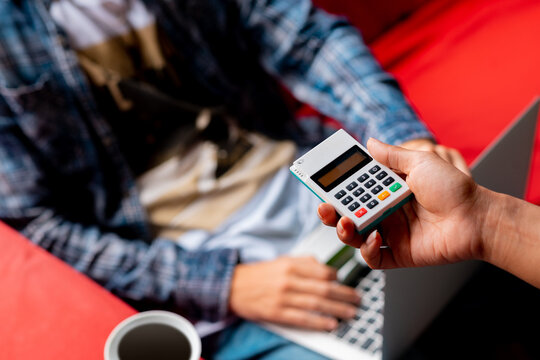 Cobrando a cliente con Mpos mientras usa su computadora en coffee shop