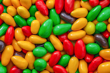 Candy seeds in multi colored sweet glaze in bulk, grains kernels seeds, close-up, wallpaper background, full depth of field.