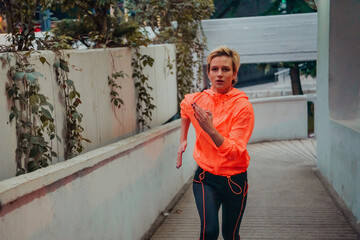 Women in sports clothes running in a modern urban environment et night time. The concept of a...