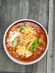 Chicken tortilla soup, topped with tortilla strips, cheese, cilantro, lime, corn, jalapeño. 