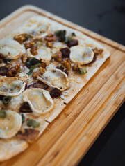 Vegetarischer Flammkuchen auf einem Holzbrett