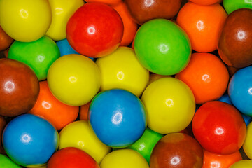 Multi-colored spherical balls candies in bulk close-up, full depth of field background wallpaper, uniform texture pattern