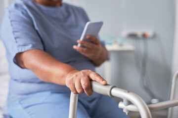 Close up of senior woman using mobility support in hospital room, copy space