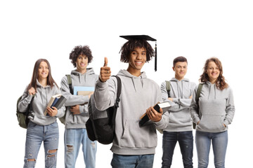 Fototapeta premium African american male student with a graduation hat gesturing thumbs up and other students posing in the back