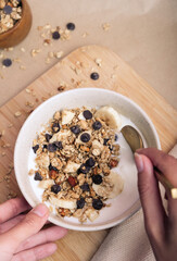 Person eating  yogurt with granola and fresh fruit. Healthy Breakfast