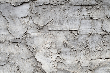 Wall is roughly plastered with streaks, grey cement putty