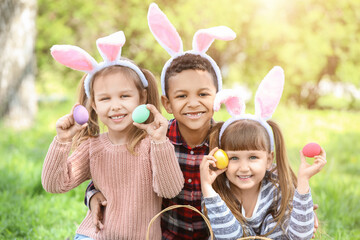 Little children with painted Easter eggs in park