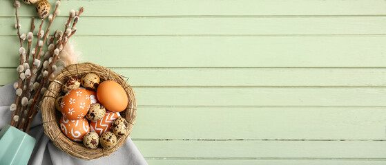 Nest of Easter eggs and pussy willow branches on wooden background with space for text © Pixel-Shot
