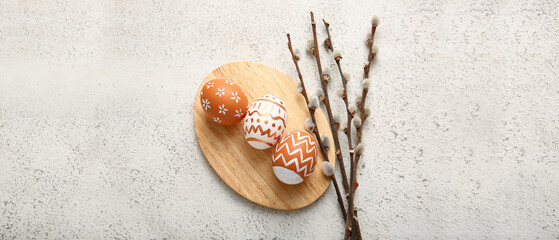 Beautiful Easter eggs and pussy willow branches on light background
