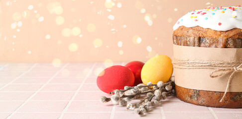 Tasty Easter cake, painted eggs and pussy willow branches on color background with space for text