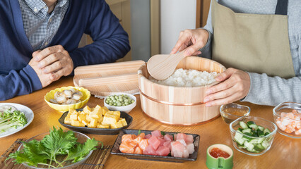 日本の料理｜ちらし寿司の調理をする男女　イメージ