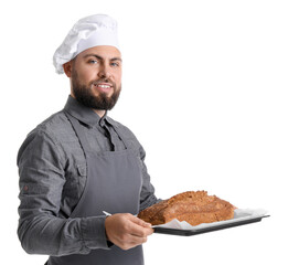 Male baker holding tray with rye bread on white background