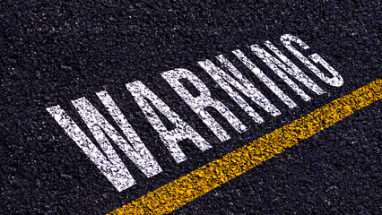 Warning written and yellow line on the road in middle of the asphalt road, Warning word on street.