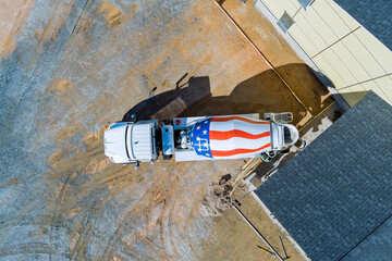 It concrete mixing truck is pouring concrete for new houses pavement