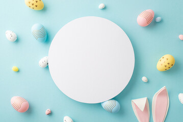 Easter composition concept. Top view photo of white circle colorful easter eggs and bunny ears on isolated pastel blue background with copyspace