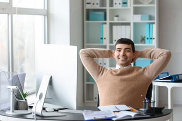 Young accountant sitting at table in office