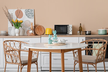 Easter rabbits with teapot and bowl of sugar on dining table in kitchen