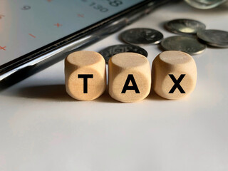 Tax-filling concept - TAX text on wooden cubes background. Close up with front view background. Stock photo.
