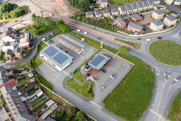 Aerial photo of a petrol station in the UK, showing solar panels on the roof. taken in the town of...