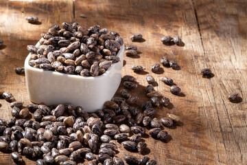Castor grains and oil on the table, close-up image