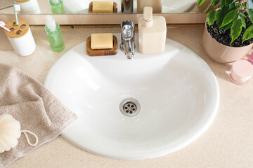 White sink and cosmetic products on table in room